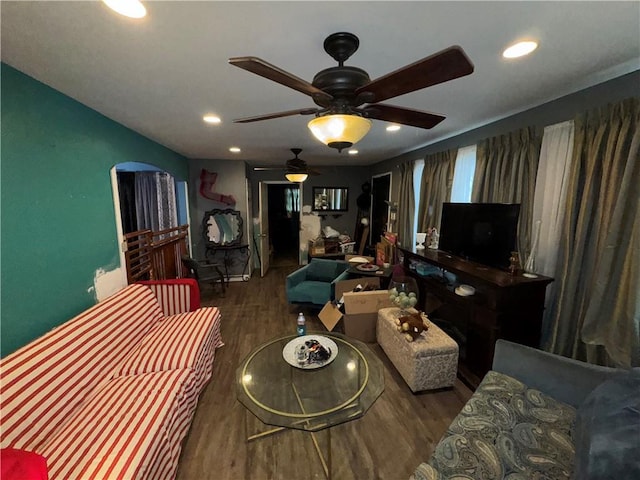 living room featuring ceiling fan and dark wood-type flooring