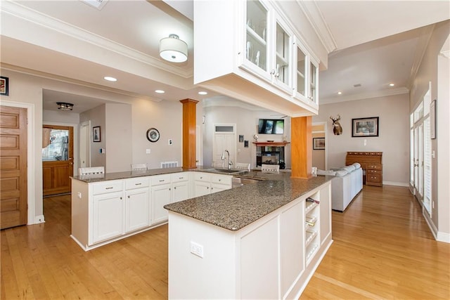 26 Pine Ln, Hammond, LA 70401 - kitchen featuring dark stone countertops, light wood-type flooring, white cabinetry, open floor plan, and glass insert cabinets