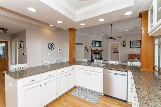 kitchen featuring kitchen peninsula, sink, dark stone countertops, dishwasher, and white cabinetry