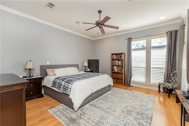 bedroom with ceiling fan, crown molding, and light hardwood / wood-style floors