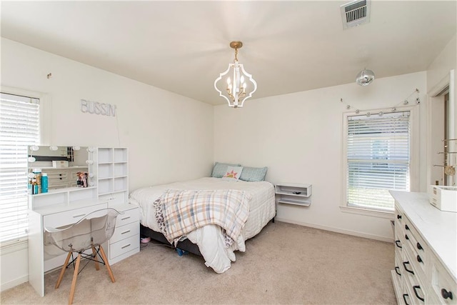 carpeted bedroom with a notable chandelier