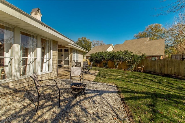 view of yard featuring an outdoor fire pit and a patio