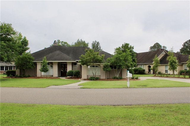 26 Pine Ln, Hammond, LA 70401 - ranch-style house with a front yard, stucco siding, and concrete driveway