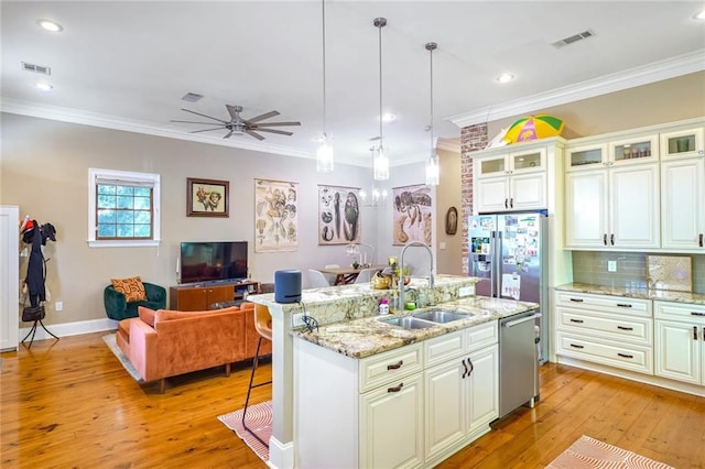 kitchen with appliances with stainless steel finishes, ceiling fan, sink, white cabinets, and hanging light fixtures