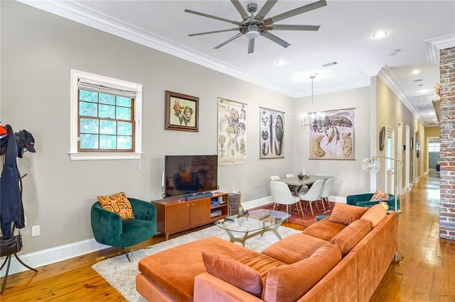 living room with light wood-type flooring, ceiling fan with notable chandelier, and ornamental molding