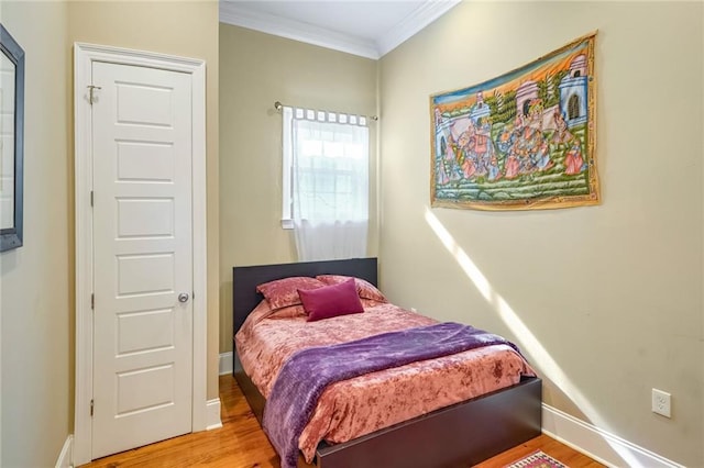 bedroom featuring wood-type flooring and ornamental molding