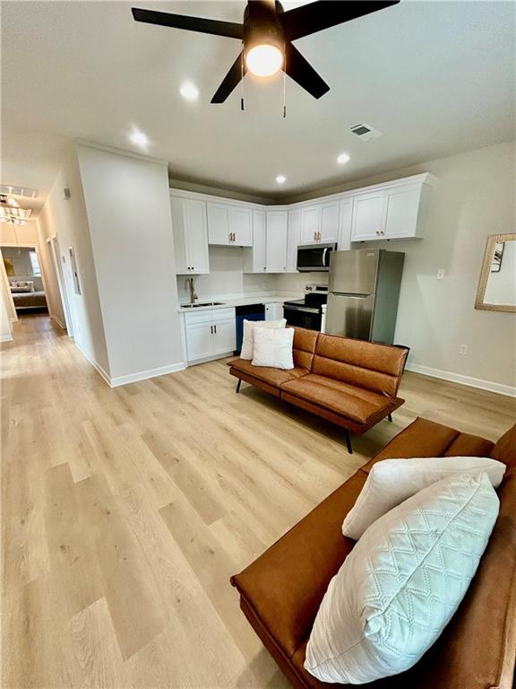 empty room with ceiling fan and light hardwood / wood-style flooring