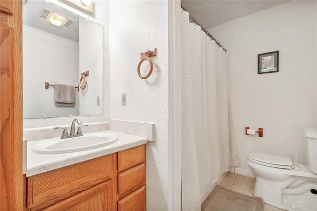 bathroom with tile patterned flooring, vanity, and toilet