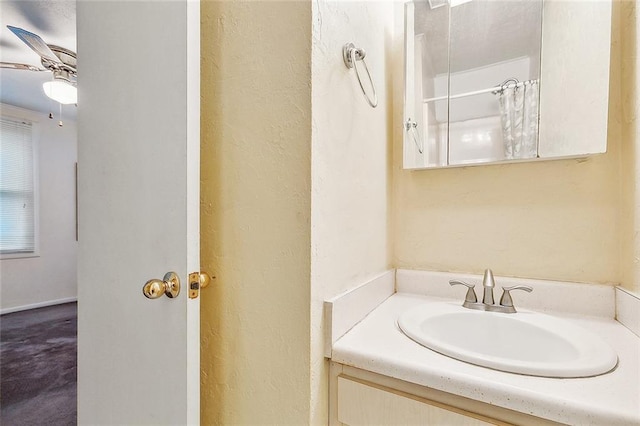 bathroom featuring curtained shower, ceiling fan, and vanity