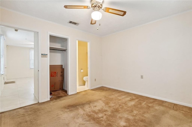 unfurnished bedroom with ensuite bathroom, ceiling fan, crown molding, and light colored carpet