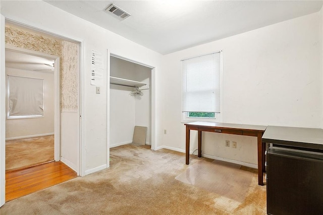 unfurnished bedroom with light colored carpet and a closet