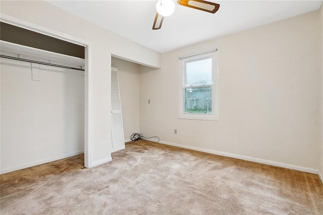 unfurnished bedroom with a closet, light colored carpet, and ceiling fan