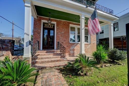 view of exterior entry with french doors, a balcony, and a porch