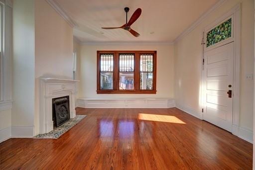 8241 Hickory St, New Orleans, LA 70118 - unfurnished living room featuring wood finished floors, ornamental molding, ceiling fan, and a fireplace with flush hearth