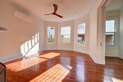 empty room with ceiling fan, ornamental molding, a wall mounted air conditioner, and dark hardwood / wood-style floors