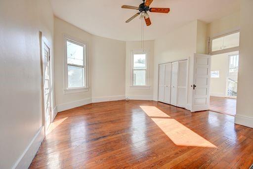 empty room with ceiling fan and hardwood / wood-style floors