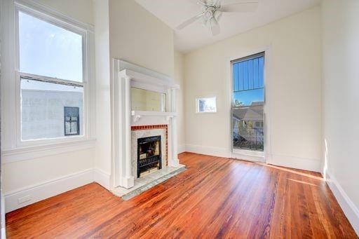 unfurnished living room with hardwood / wood-style flooring and ceiling fan