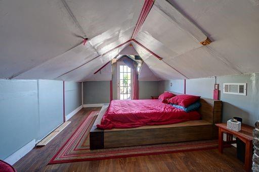 bedroom featuring lofted ceiling and dark hardwood / wood-style floors