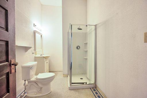 bathroom featuring vanity, tile patterned flooring, toilet, and walk in shower