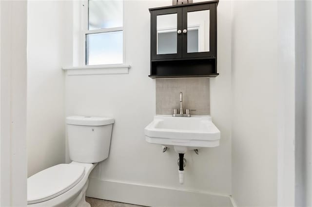 bathroom featuring decorative backsplash and toilet