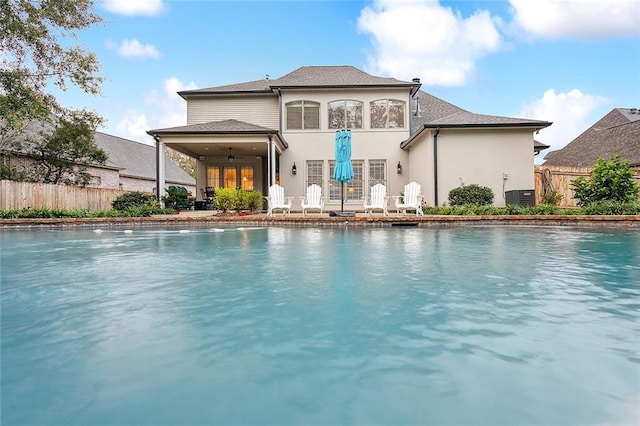 back of house featuring a patio, a fenced in pool, central AC, and ceiling fan