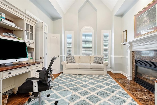 office space with a fireplace, dark hardwood / wood-style flooring, and vaulted ceiling