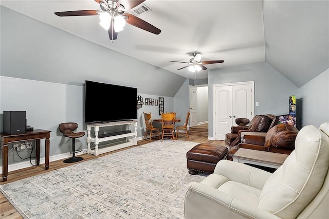 living room with hardwood / wood-style flooring, vaulted ceiling, and ceiling fan