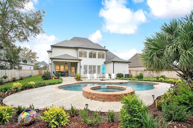 back of property featuring ceiling fan, a patio, and a pool with hot tub