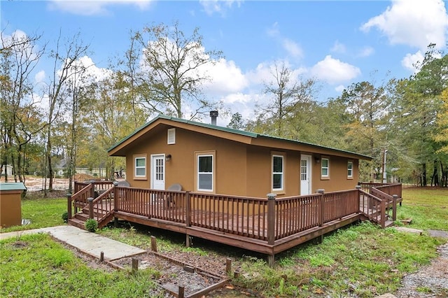 rear view of property featuring a lawn and a wooden deck