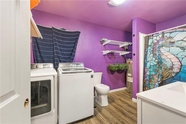 clothes washing area featuring washer and dryer and wood-type flooring