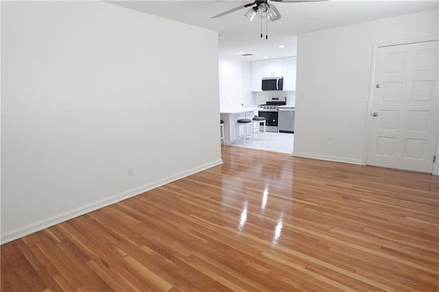 empty room featuring light hardwood / wood-style flooring and ceiling fan