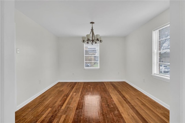 unfurnished dining area with wood-type flooring and a notable chandelier