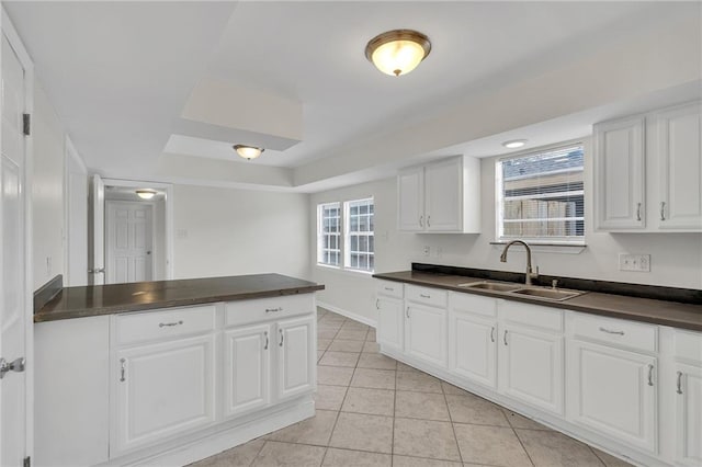 kitchen featuring light tile patterned flooring, white cabinetry, and sink