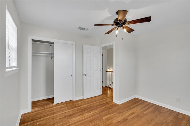 unfurnished bedroom with ceiling fan, a closet, and light hardwood / wood-style floors