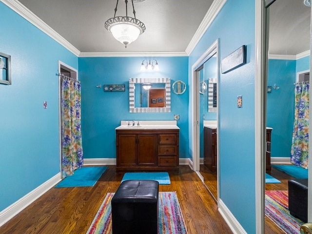 bathroom with crown molding, hardwood / wood-style floors, and vanity