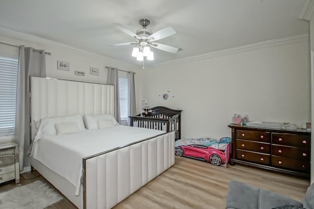 bedroom with ceiling fan, light hardwood / wood-style floors, and ornamental molding