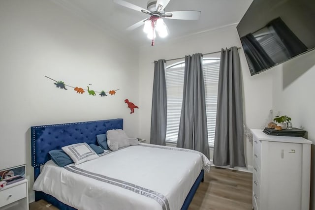 bedroom featuring hardwood / wood-style floors, ceiling fan, and crown molding