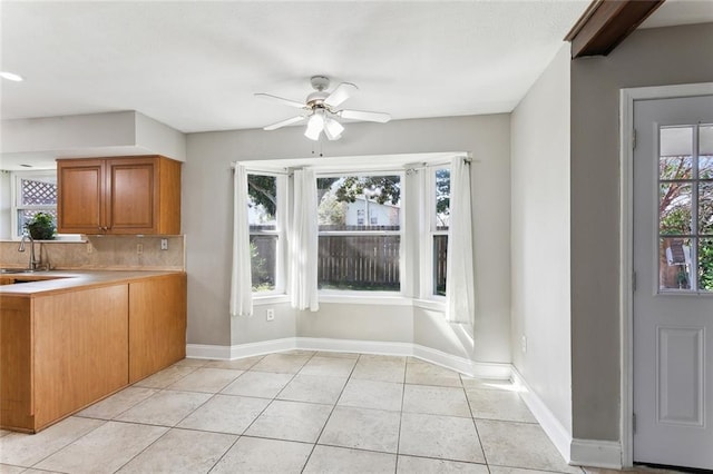 kitchen featuring ceiling fan, light tile patterned flooring, sink, and tasteful backsplash