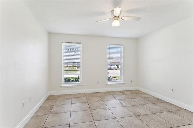 tiled empty room featuring ceiling fan