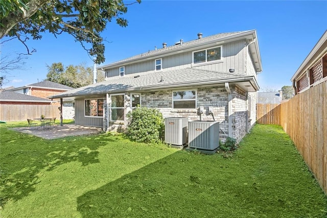 rear view of property featuring central air condition unit, a lawn, and a patio