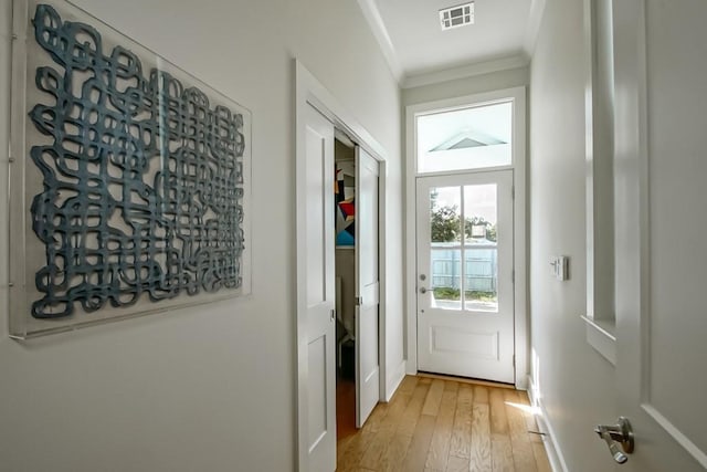 entryway featuring light hardwood / wood-style floors and crown molding