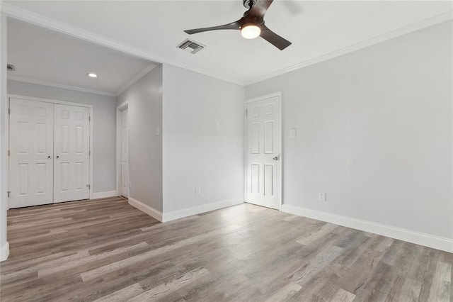 empty room with light wood-type flooring, ceiling fan, and crown molding