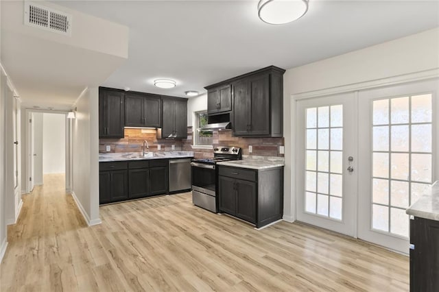 kitchen featuring french doors, sink, light hardwood / wood-style flooring, tasteful backsplash, and stainless steel appliances