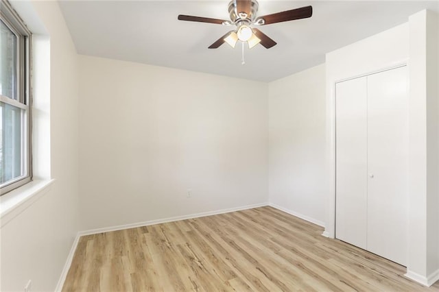 empty room with ceiling fan and light hardwood / wood-style flooring