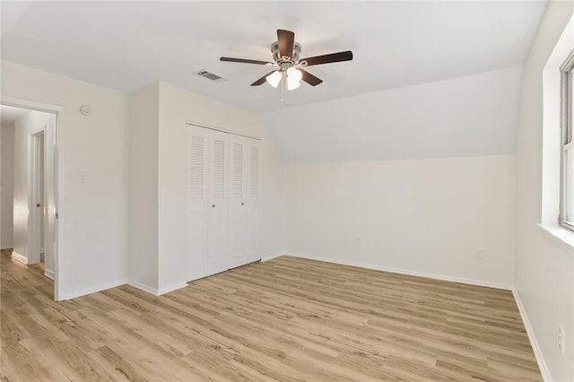 interior space featuring ceiling fan, vaulted ceiling, light hardwood / wood-style flooring, and a closet