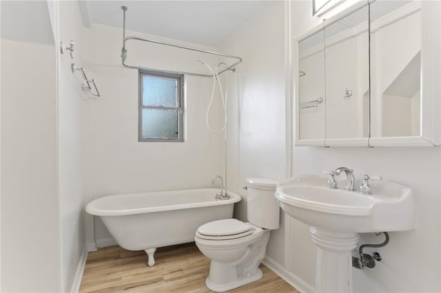 bathroom with wood-type flooring, shower / bathtub combination, and toilet