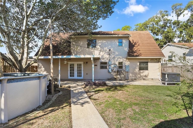 rear view of property with french doors, a yard, and a patio area