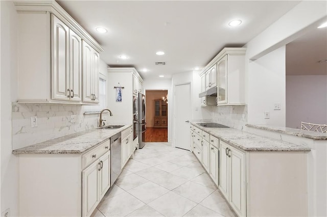 kitchen with white cabinets, light stone counters, sink, and stainless steel appliances