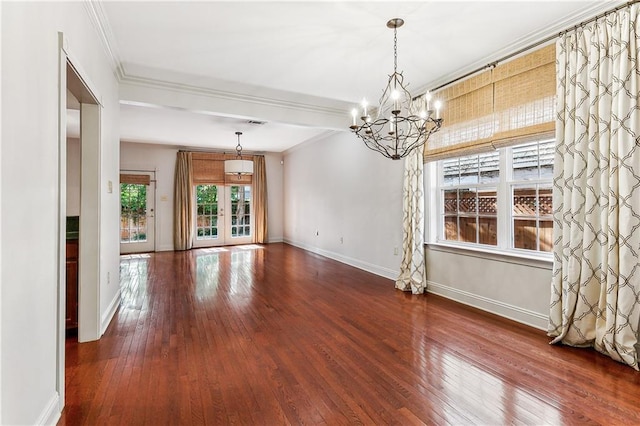 empty room featuring a chandelier, wood-type flooring, crown molding, and french doors