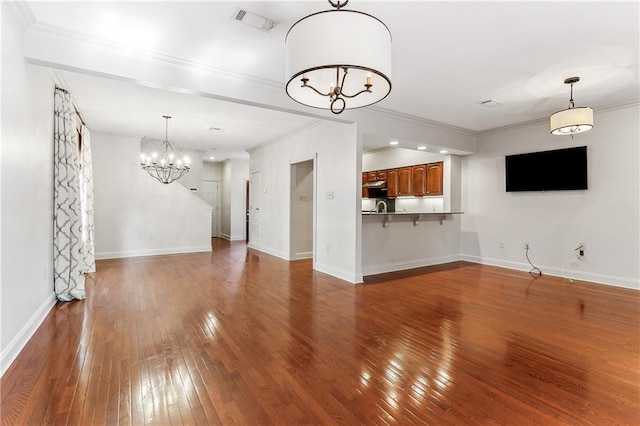 unfurnished living room with crown molding, sink, wood-type flooring, and a notable chandelier